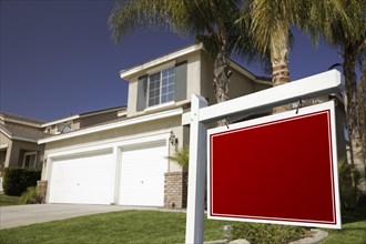 Blank real estate sign in front of house