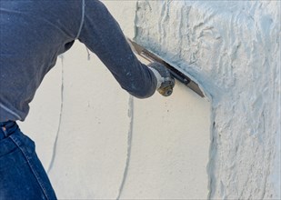 Worker smoothing wet pool plaster with trowel