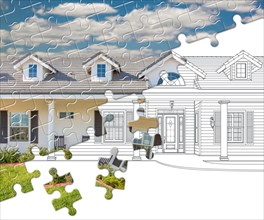 Puzzle pieces fitting together revealing finished house build over drawing