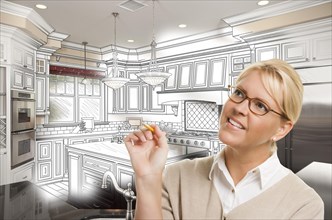 Creative woman with pencil over custom kitchen design drawing and photo combination