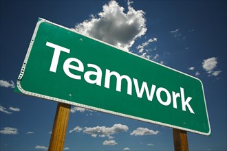 Teamwork road sign with dramatic blue sky and clouds