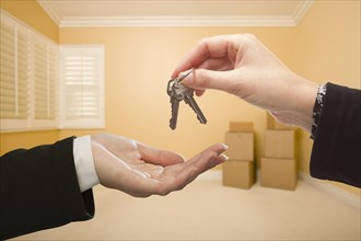 Woman handing over the house keys to A new home inside empty room