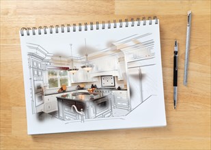Sketch pad on desk with drawing of custom kitchen and brush stroke showing finished construction next to engineering pencil and ruler scale