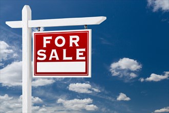 Right facing for sale real estate sign over blue sky and clouds with room for your text