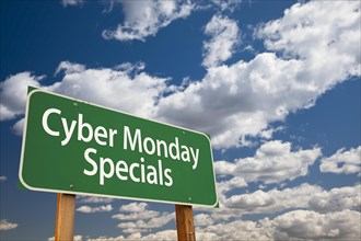 Cyber monday specials green road sign with dramatic clouds and sky