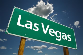Las vegas green road sign over dramatic blue sky and clouds