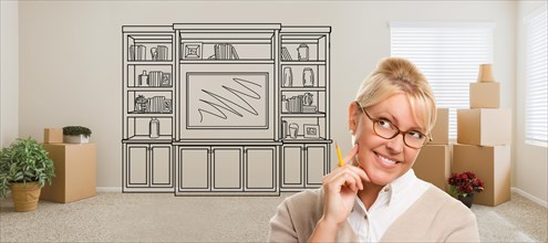Woman inside room with moving boxes glancing toward entertainment unit drawing on wall