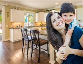 Young mother and son inside beautiful custom kitchen