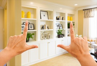 Hands framing custom built-in shelves and cabinets wall design inside home