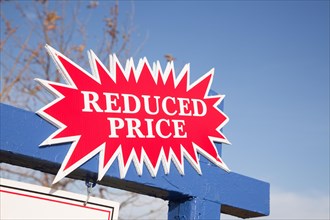 Red reduced price burst real estate sign