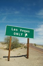 Green las vegas road sign in the desert