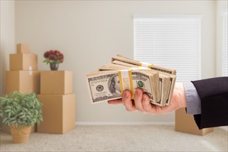 Man handing over cash in room with packed moving boxes