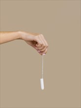 hand holding tampon front view