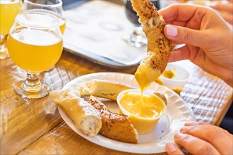 Woman enjoys warm pretzels and micro brew beer