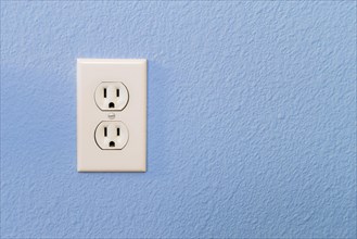 Electrical sockets in colorful blue wall of house