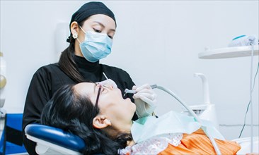 A dentist cleaning a patient's mouth