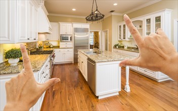 Female hands framing A beautiful custom kitchen interior