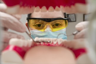 A dentist cleaning a mouth inside view