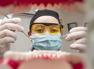 A dentist cleaning a mouth inside view