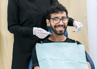 Dentist examining mouth to smiling patient