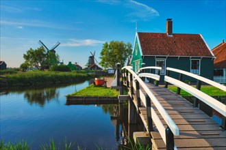 Netherlands rural lanscape with bridge over canal at windmills at famous tourist site Zaanse Schans in Holland Zaandam