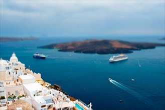 View of Fira Greek town with traditional white houses on Santorini island with cruise ships in sea Santorini