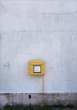 Yellow Deutsche Post letterbox on white wall