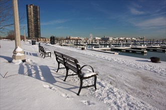 Empty snowy bench in chicago after winter snow along lake shore drive