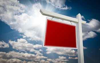 Blank red real estate sign over clouds and sky ready for your own message
