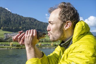 Man kisses caught trout