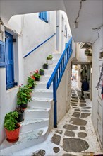 Picturesque scenic narrow Greek streets with traditional whitewashed houses with blue doors windows of Mykonos town in famous tourist attraction Mykonos island