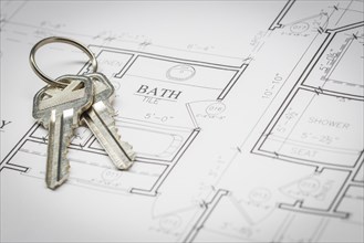 Set of new house keys resting on custom house plans