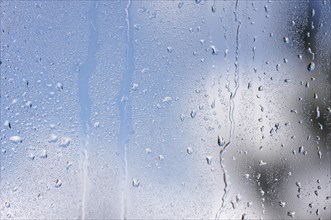 Rain drops on window as the clouds clear behind
