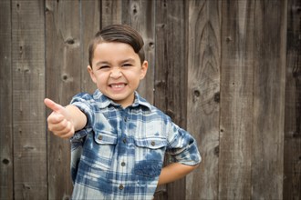 Happy young mixed-race boy making thumbs up hand gesture