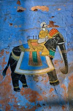 Mural of Maharajah on elephant on blue house wall in Jodhpur also known as Blue City due to the vivid blue-painted Brahmin houses. Johdpur