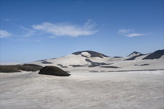 Barren hilly volcanic landscape of snow and lava fields