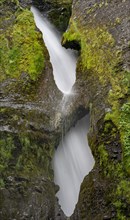 Waterfall behind two rock holes