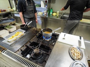 Chef making apotato sauce cream reduction in a professional kitchen of a restaurant