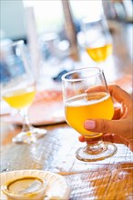 Female hand holding glass of micro brew beer at bar