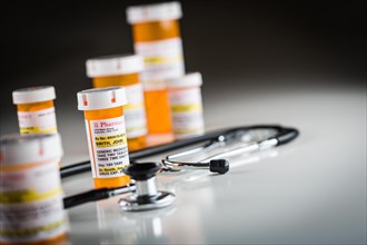 Several non-proprietary medicine prescription bottles abstract with stethiscope