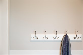 Wall in house with scarf hanging on coat rack hooks abstract