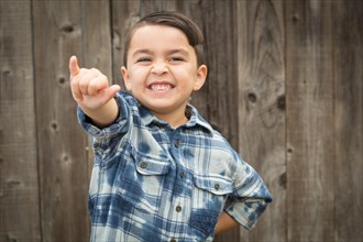 Happy young mixed-race boy making hawaiin shaka hand gesture