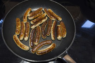 Nuremberg sausages in a pan on the cooker