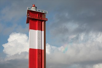 Modern lighthouse in the sky with rainbow