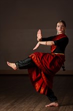 Young woman in sary dancing classical traditional indian dance Bharat Natyam