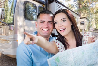 Young military couple looking at map in front of RV