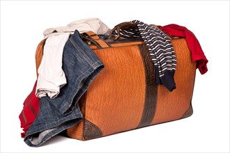 Overstuffed baggage in old suitcase isolated on white background