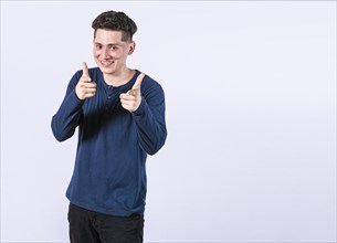 Young man with thumbs up on white background