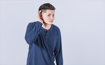 Man with hand to his ear listening to something