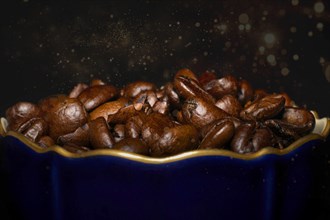 Roasted coffee of the Arabica variety in a porcelain cup in cobalt blue with gold rim